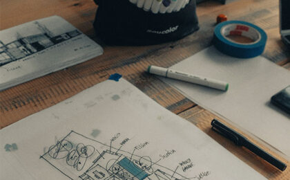Architectural sketch on a desk with markers, tape, and design tools.
